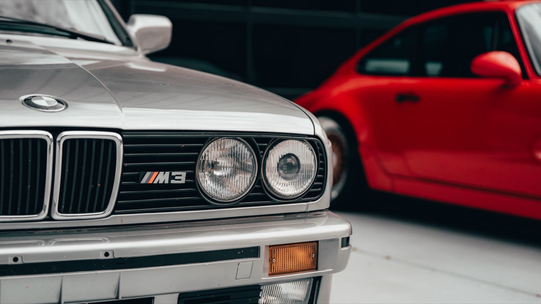 BMW E30 M3 and an orange Porsche 911