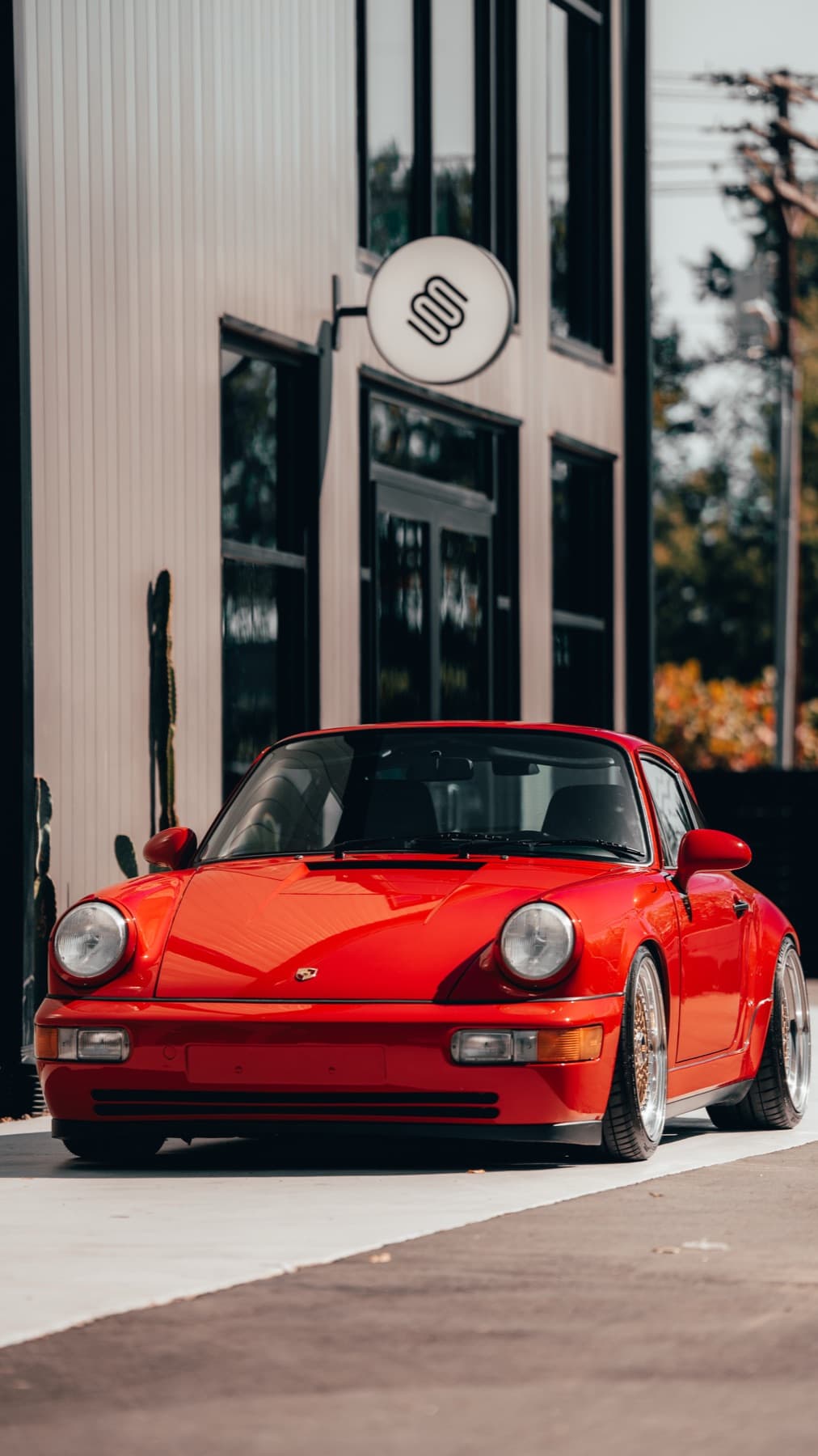 Front of an orange Porsche 911 outside the shop