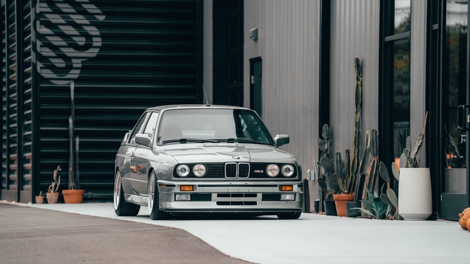 Silver BMW E30 M3 outside the Eurowise building