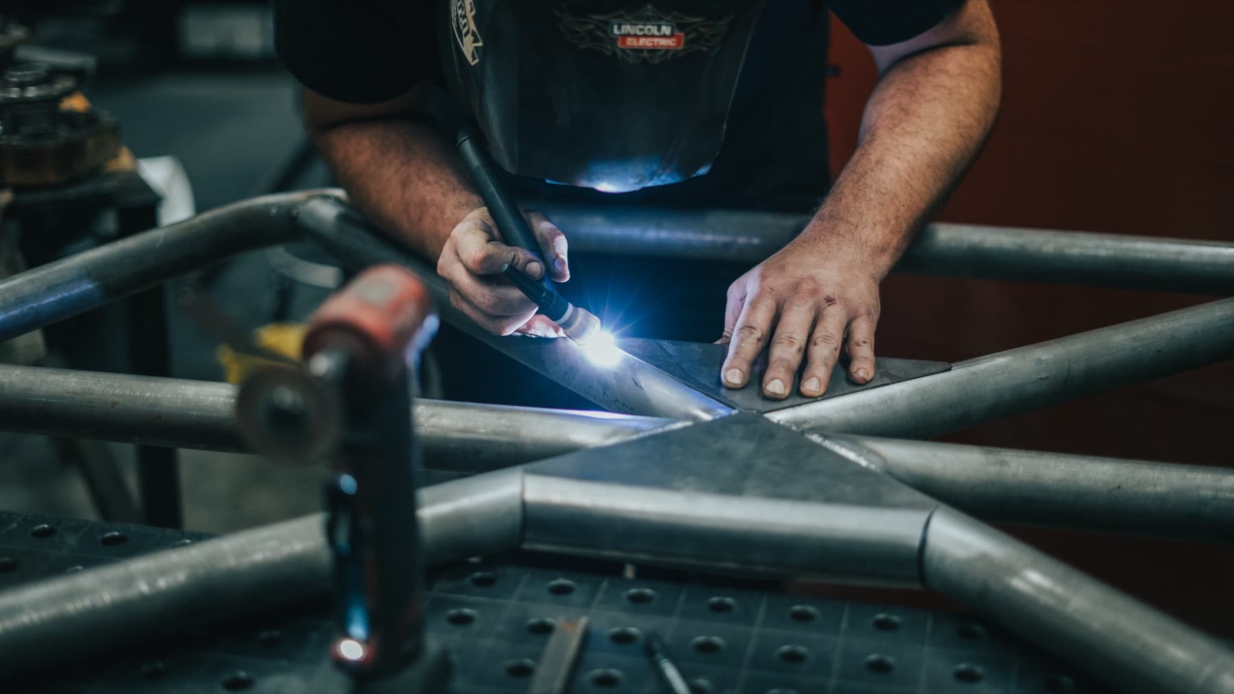 Fabricator welding a tube frame