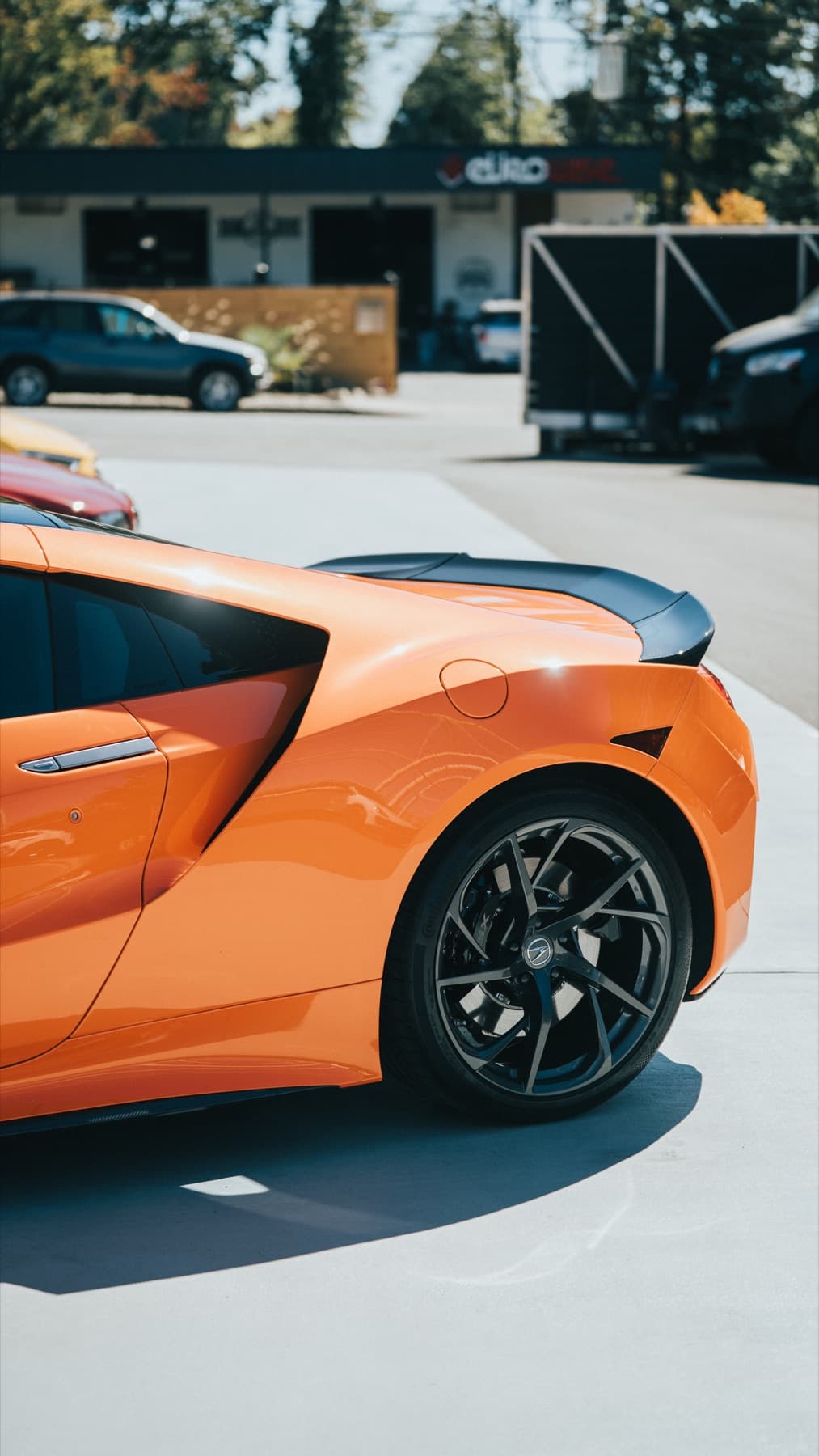 Orange sports car outside the shop