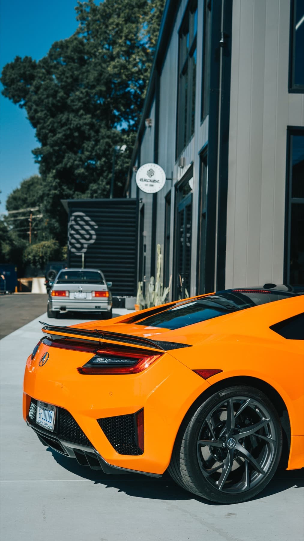 Rear three-quarter view of an orange Acura NSX