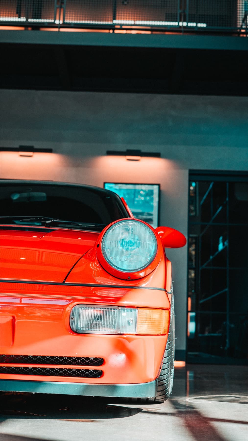 Rear of an orange classic Porsche 911 in the showroom
