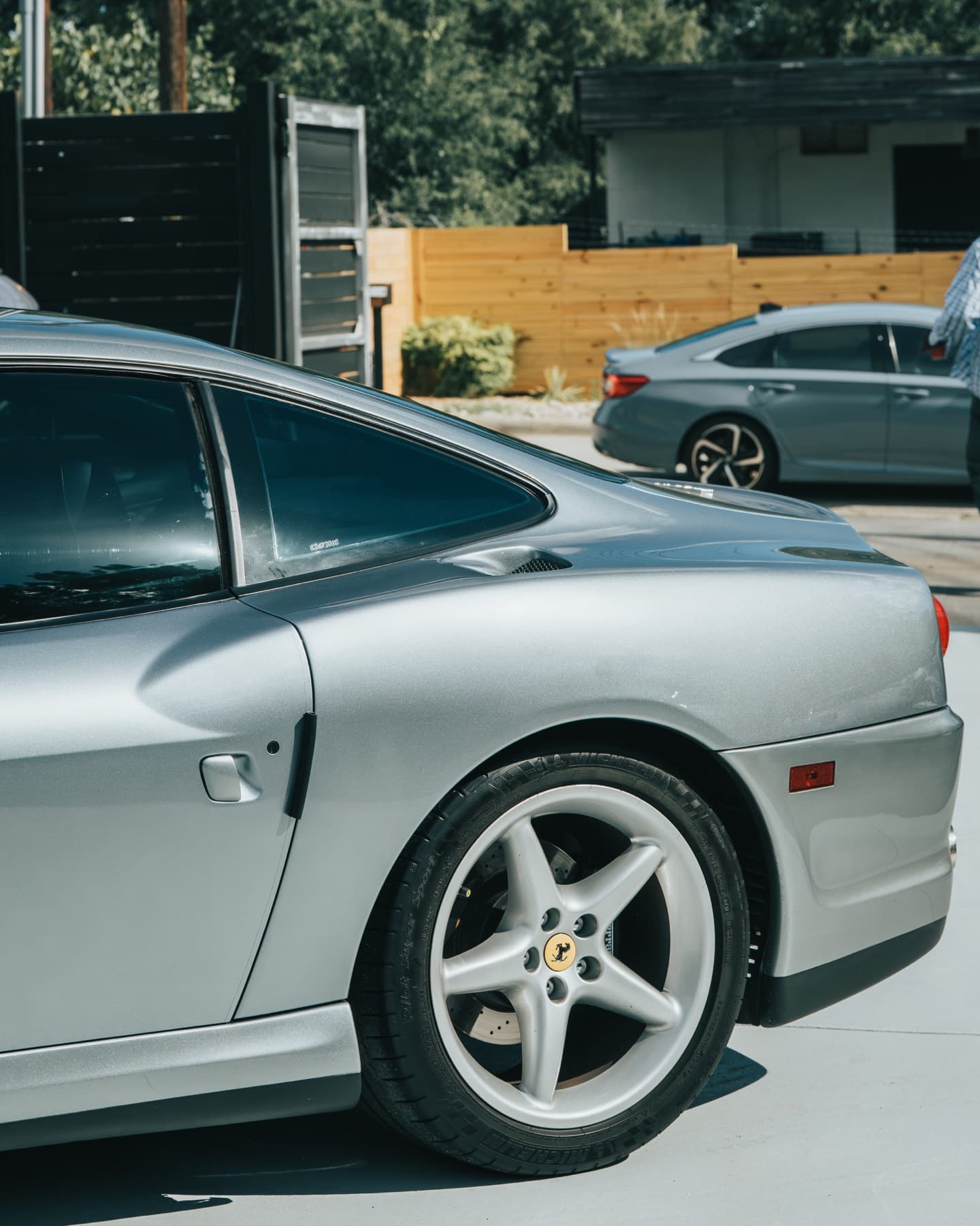 Rear three-quarter view of a silver Ferrari 550