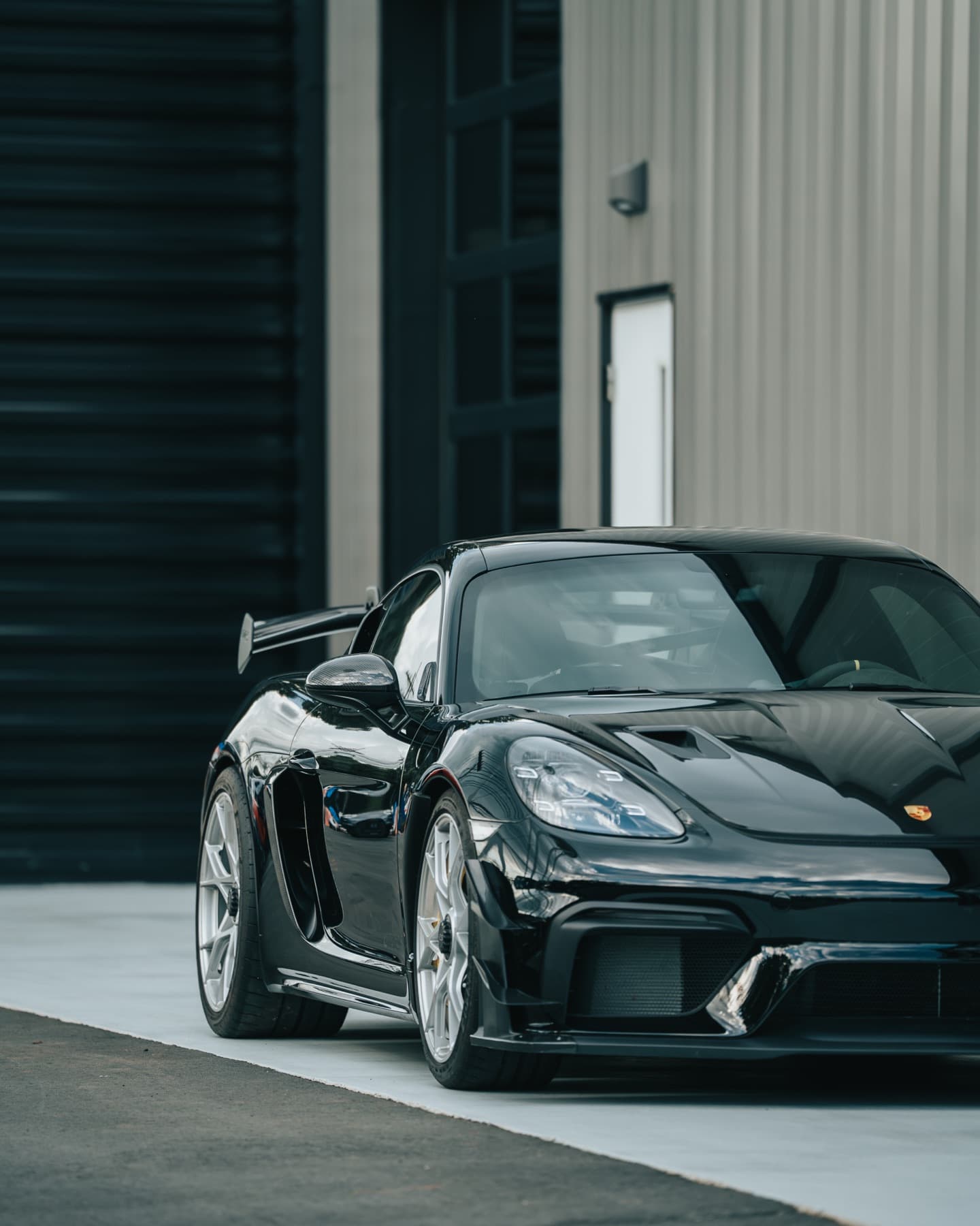 Black Porsche Cayman GT4 outside the shop