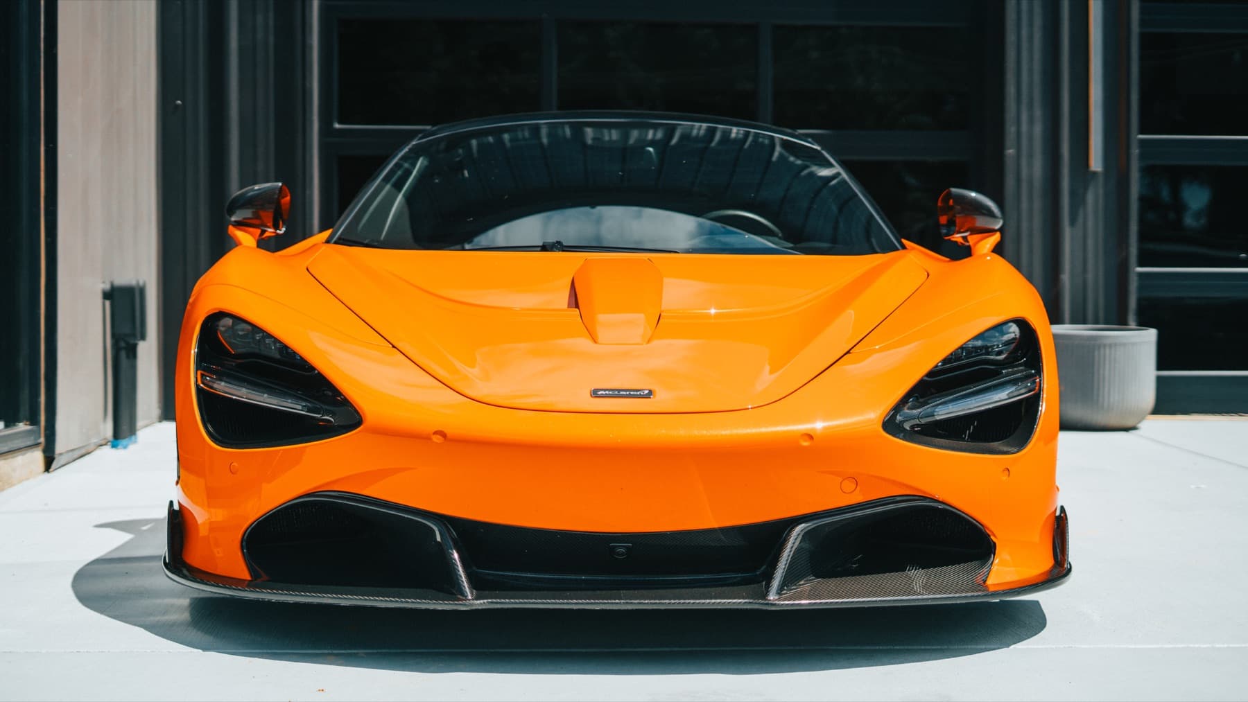 Front of an orange McLaren 720S outside the Eurowise building