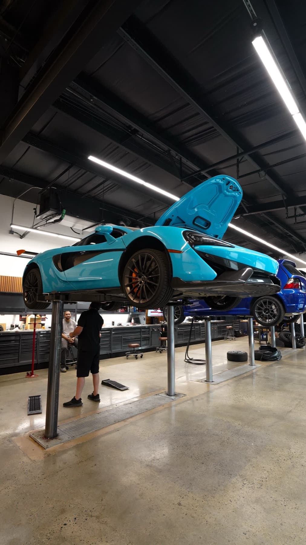 Light blue McLaren raised on a lift