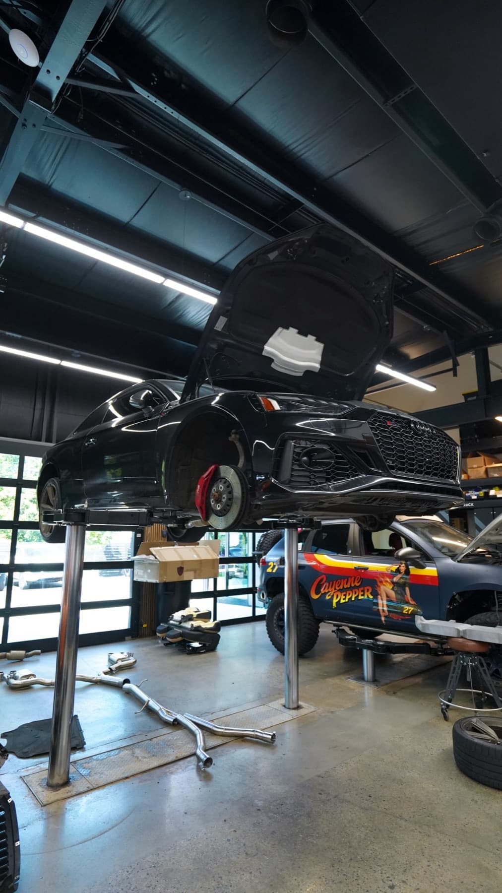 Dark car on a lift with its wheels off