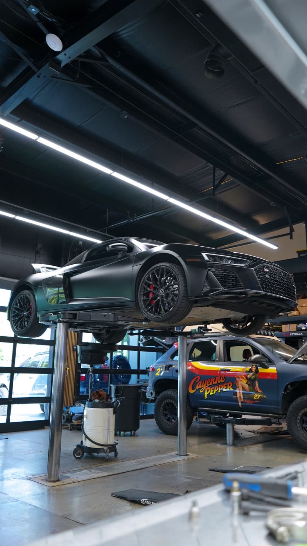 Silver car raised high on a lift