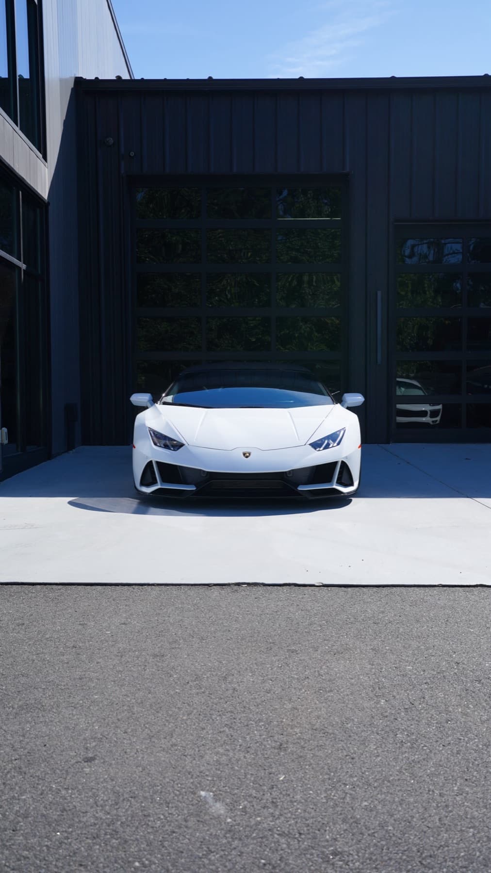 White Lamborghini Huracán at the shop door