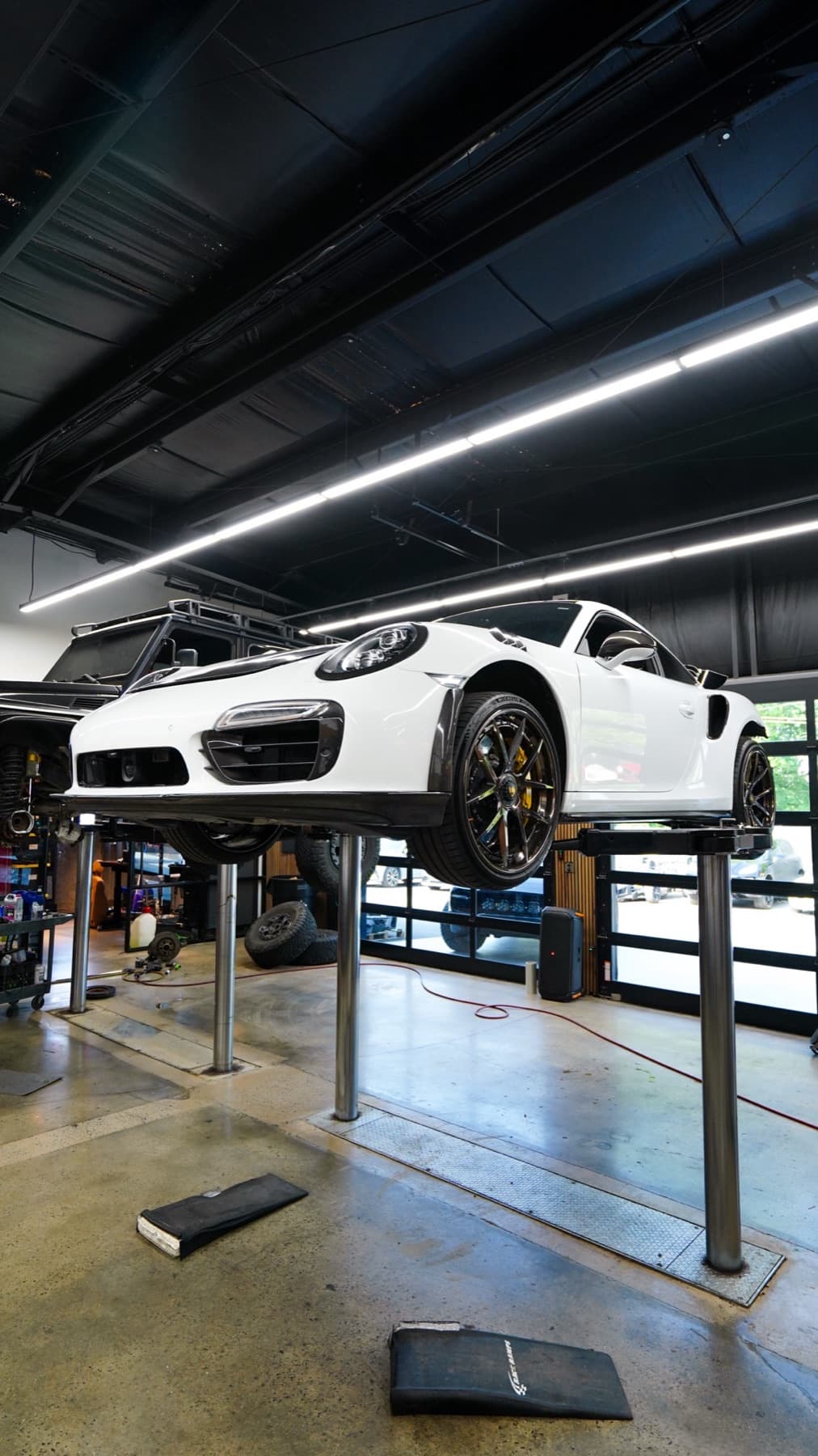 White Porsche 911 raised on a lift