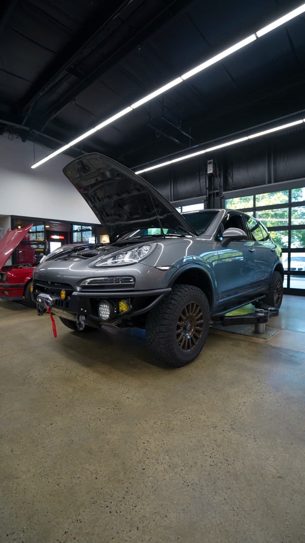 Silver off-road Porsche with its hood open
