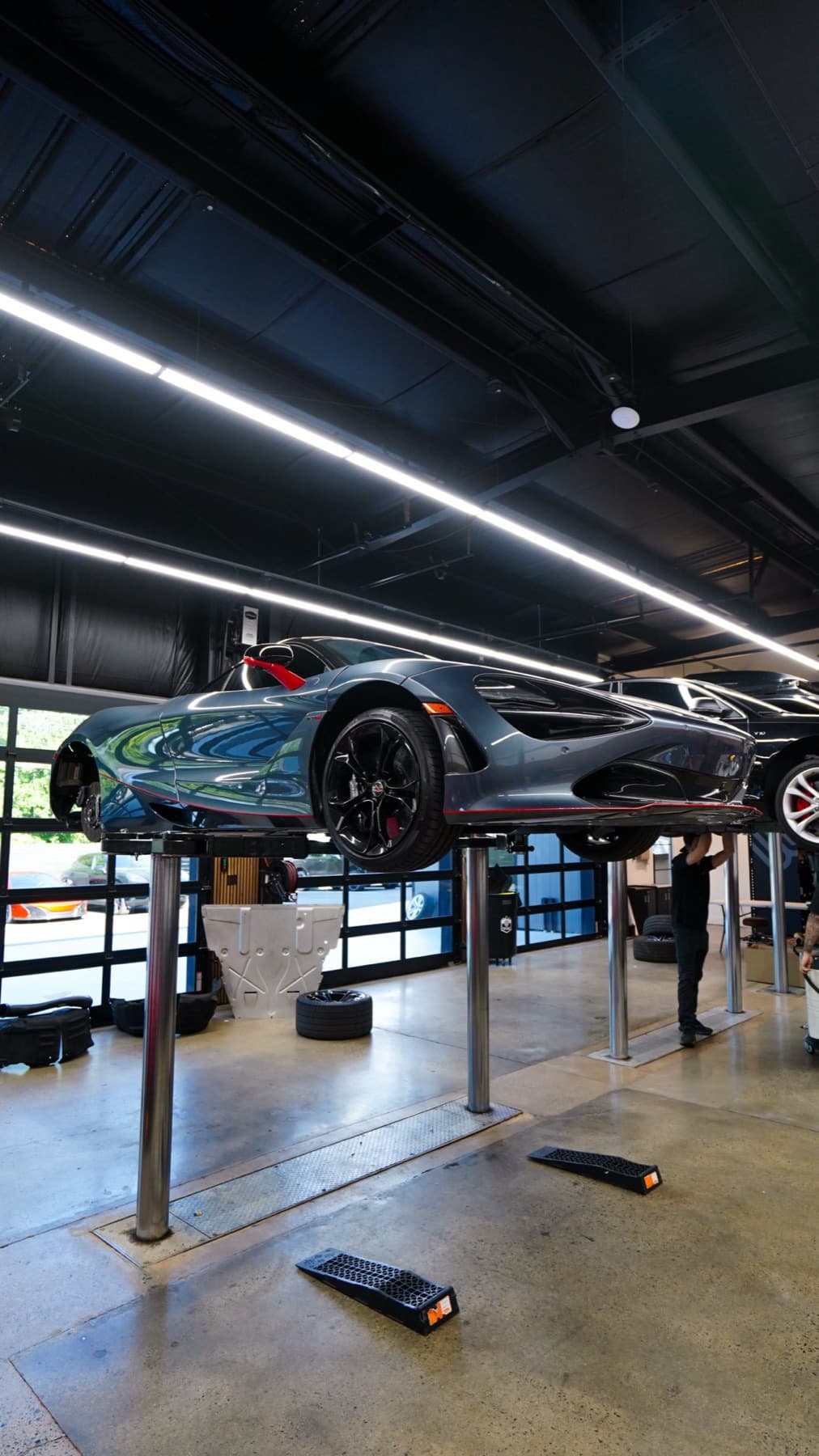 Grey car on a lift in the service bays