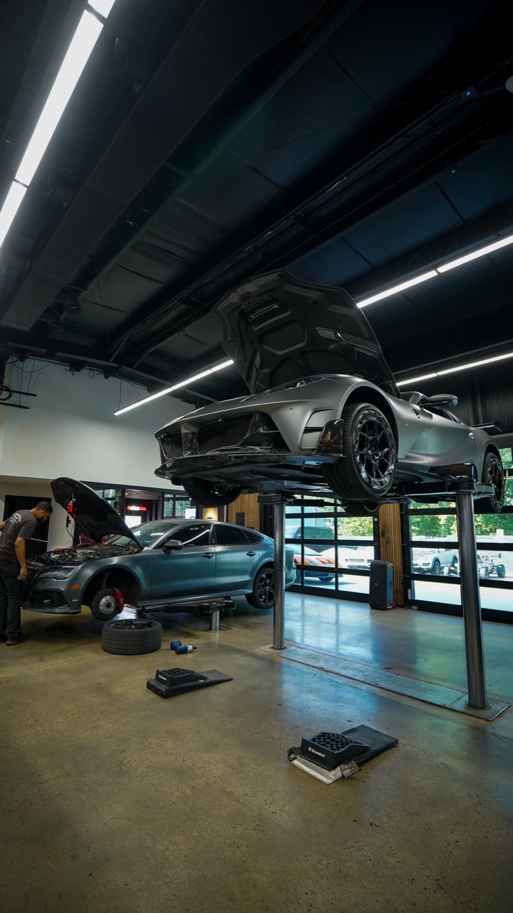 Car raised high on a lift above the service bays