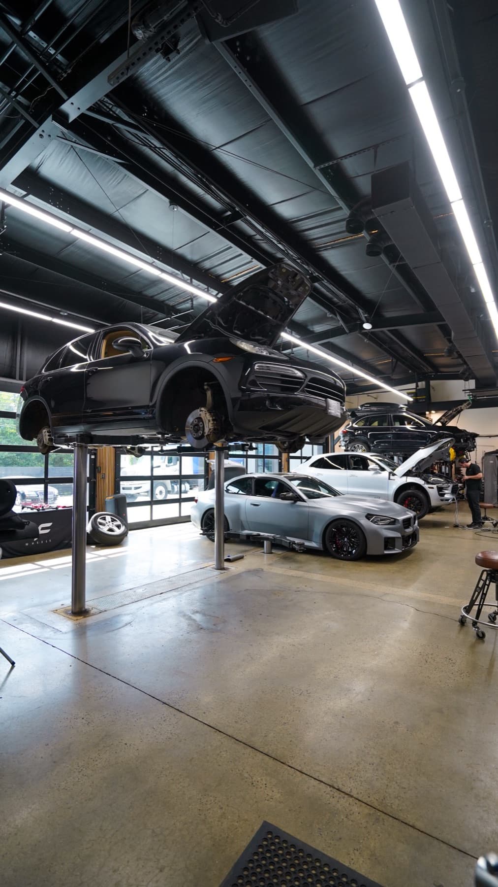 Two cars on lifts in the service bays