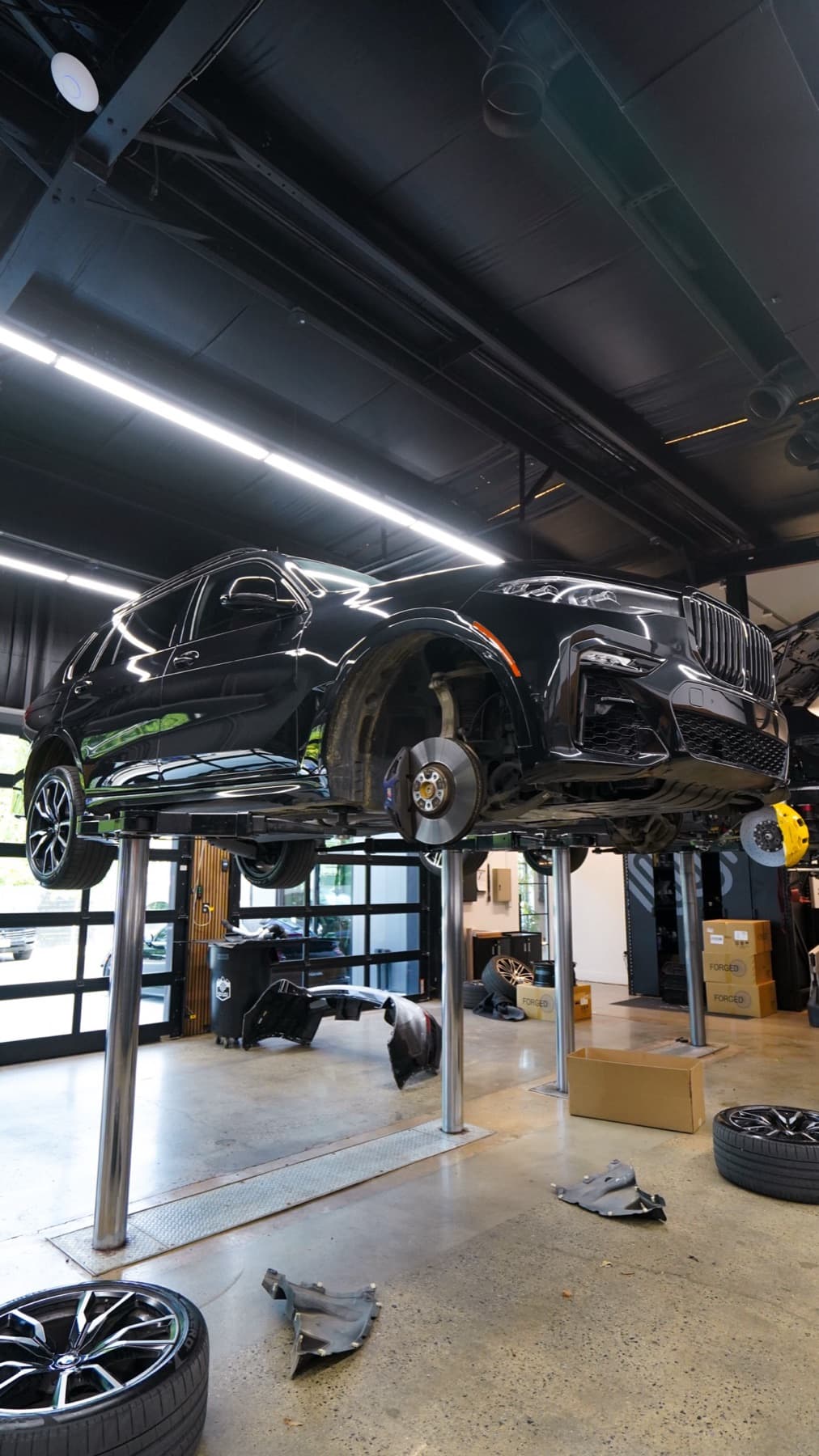 Dark SUV on a lift with its wheels off