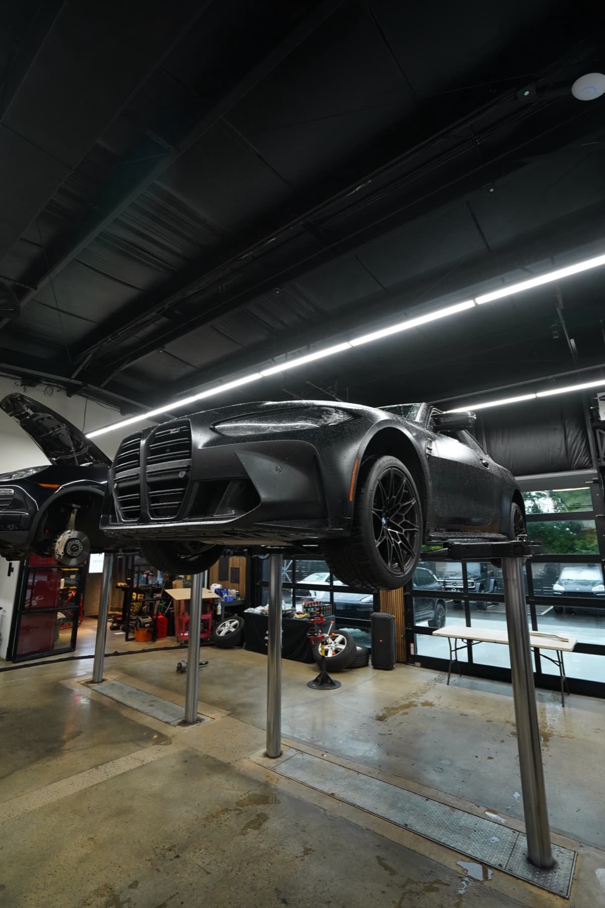 Two dark cars on lifts