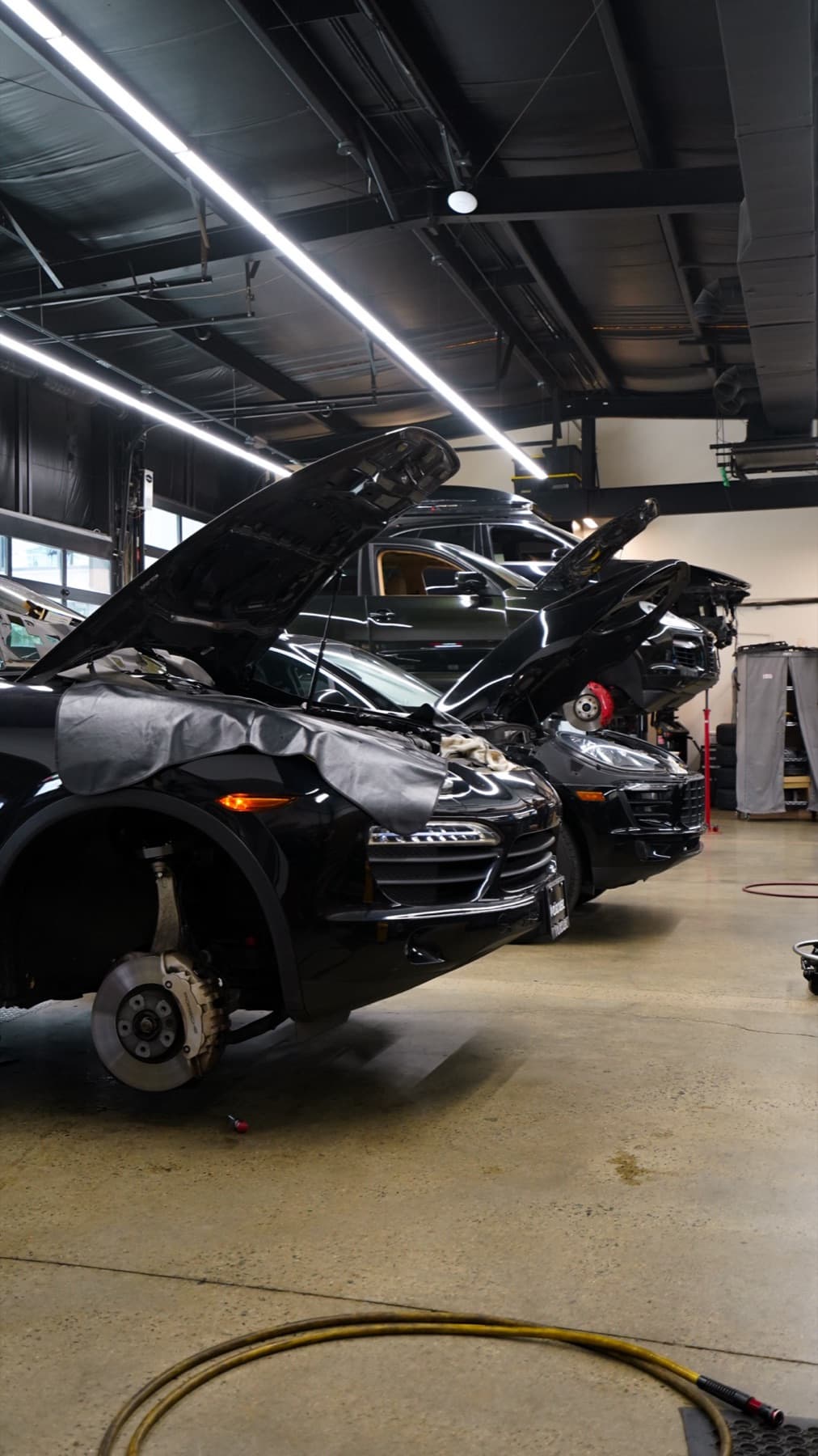 Black car on a lift with its hood open