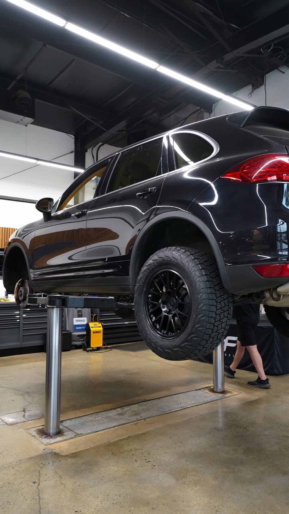 Black Porsche Cayenne raised on a lift