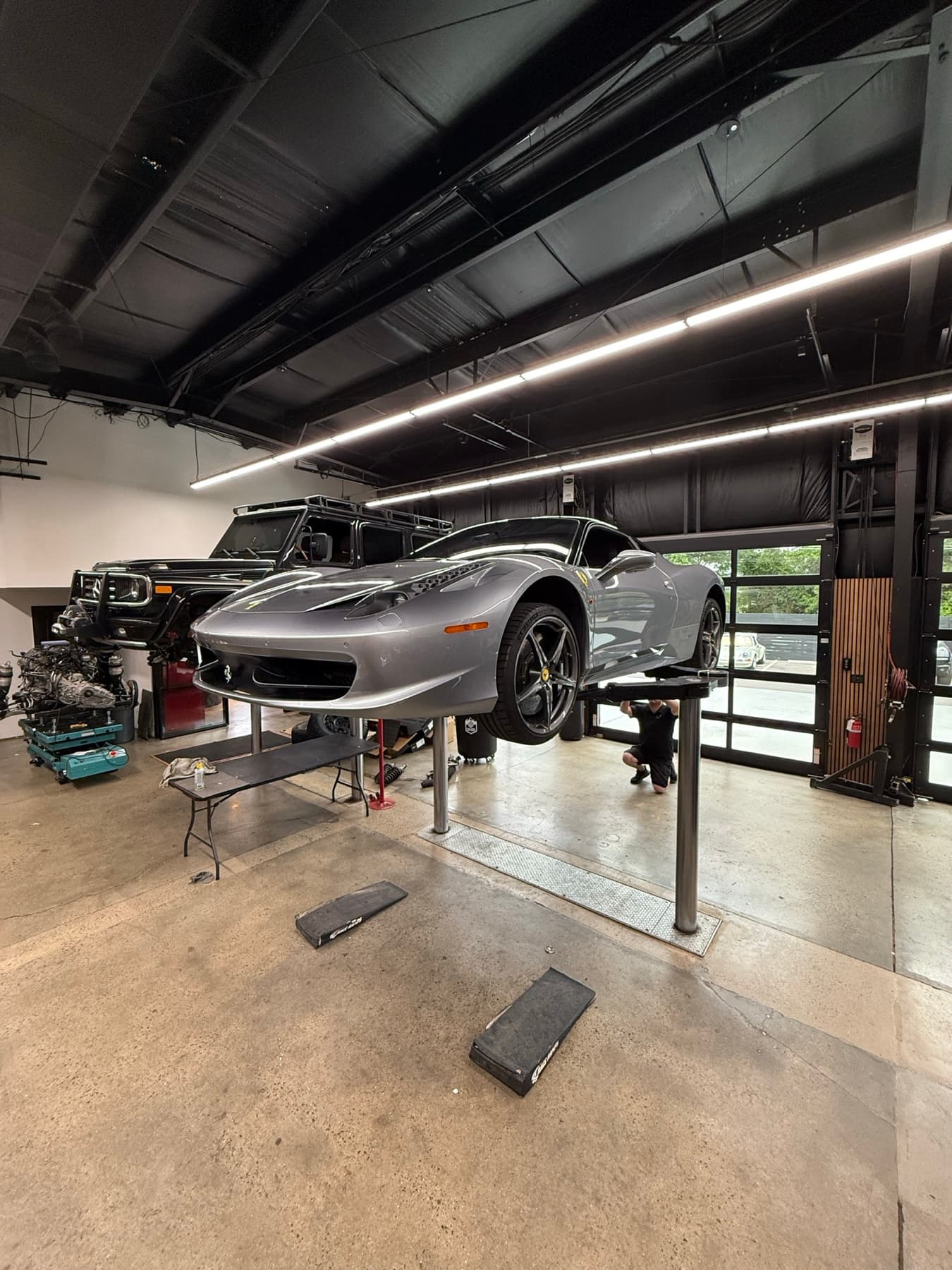 Silver car on a lift in the service bays